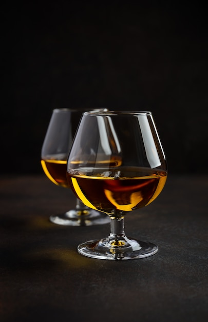 Glass of brandy or cognac on the old rusty background.