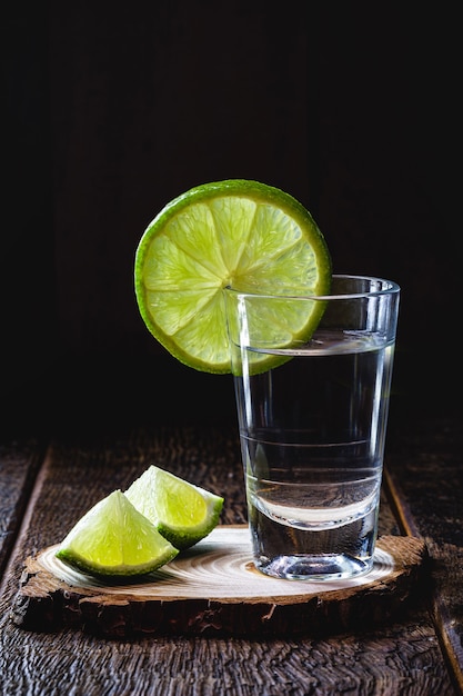 glass of Brazilian distilled drink with lemon, called cachaça or "pinga", copy space