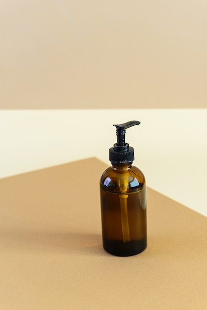 glass brown bottle for cream on a beige
