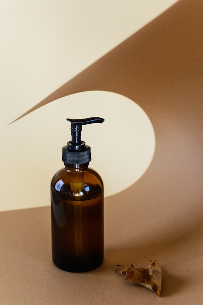 Glass brown bottle for cream on a brown