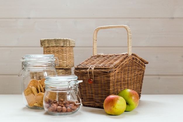 Lattine di vetro con noci e biscotti e mele sul tavolo in legno concetto di picnic zero rifiuti