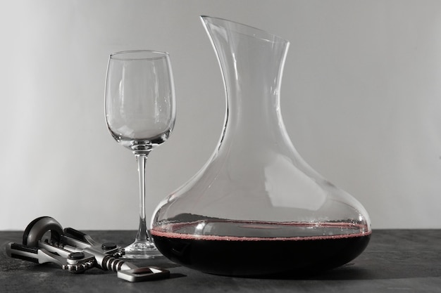 Фото Стеклянный графин красного вина на сером столе
