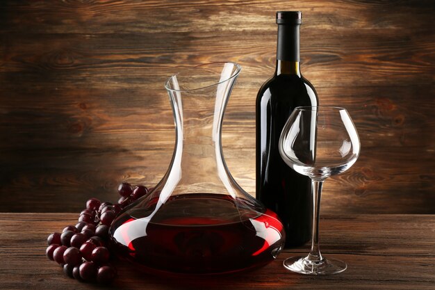 Glass carafe of wine on wooden wall