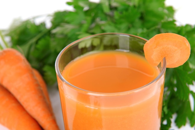 Foto un bicchiere di succo di carota con carote fresche e prezzemolo da vicino