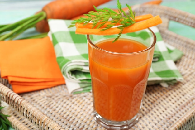 Foto bicchiere di succo di carota con fette di verdure sul tavolo da vicino