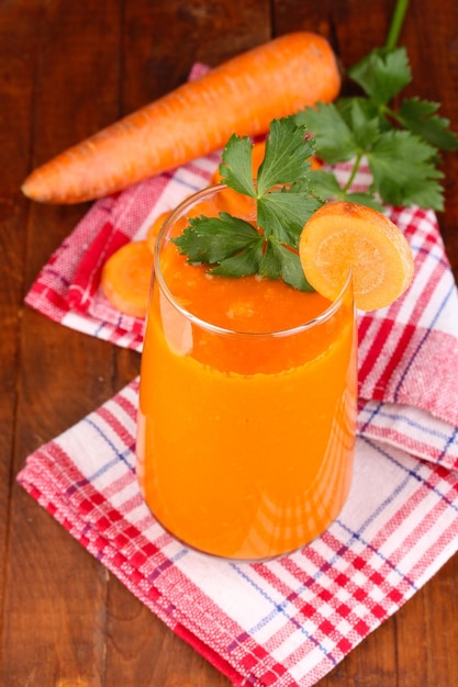 Foto bicchiere di succo di carota sulla tavola di legno