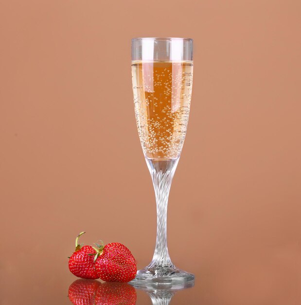 A glass of champagne on a beige background