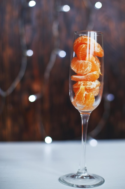 A glass of champagne with tangerines and a burning sparkler