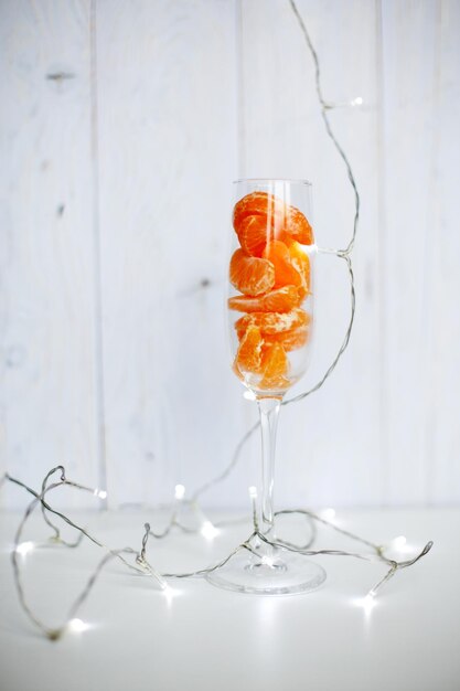 A glass of champagne with tangerines and a burning sparkler