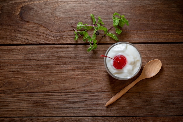 Glass of Cherry yogurt on a brown wood table