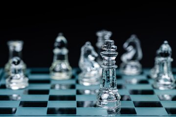 Premium Photo  Glass chess board game in black background selective focus  on king leadership concept