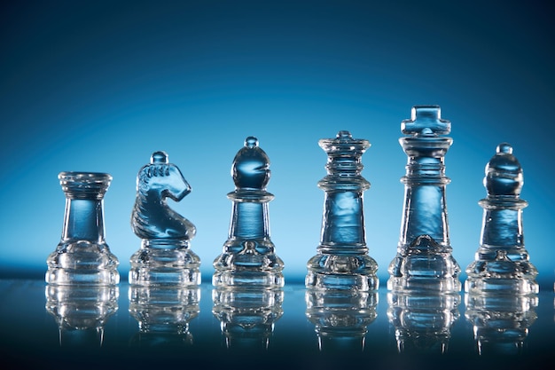 Glass chess on the chess board against blue background