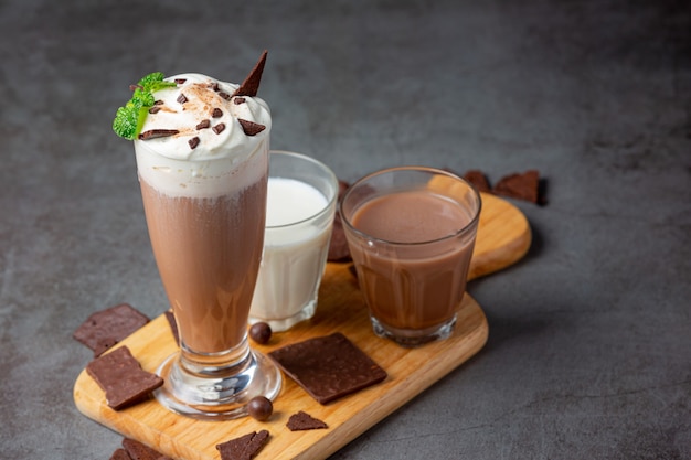 Glass of chocolate milk on the dark surface.