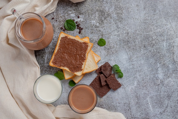 Glass of chocolate milk on the dark surface.