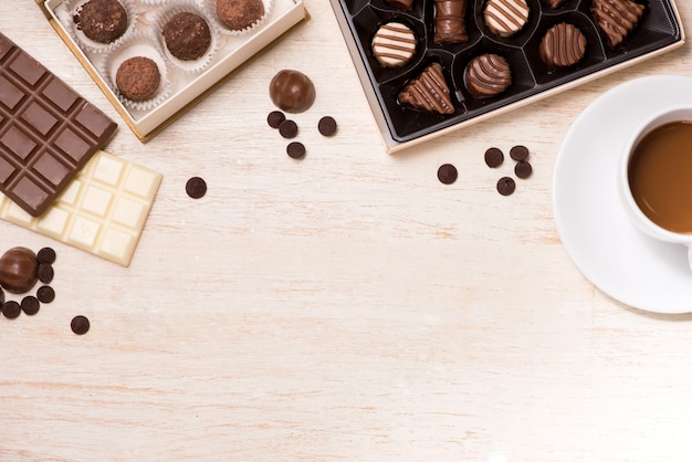 Glass of chocolate milk and variety chocolates  on table