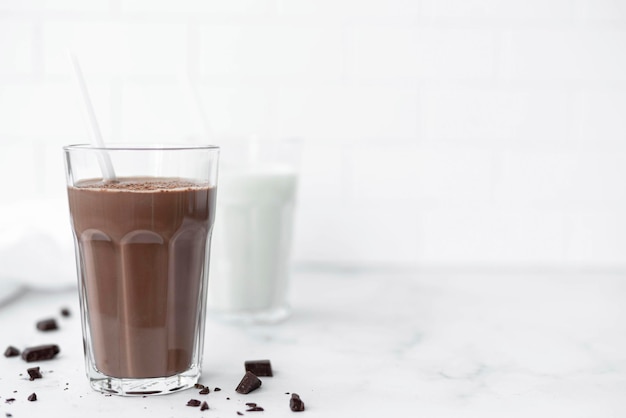Photo a glass of chocolate milkshake with a straw copy space