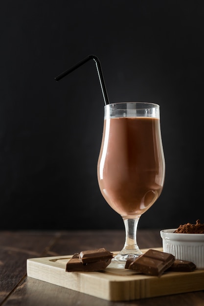 Glass of chocolate milkshake with straw