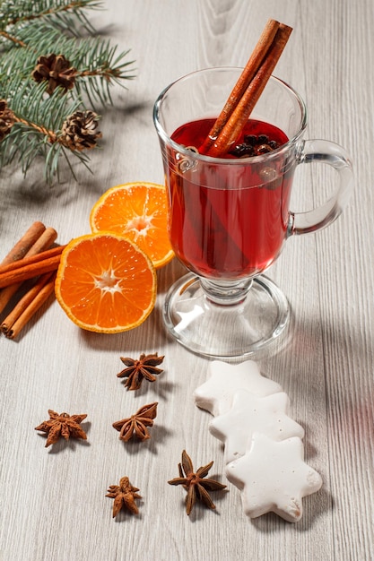 Glass of Christmas mulled wine with spices orange and cookies