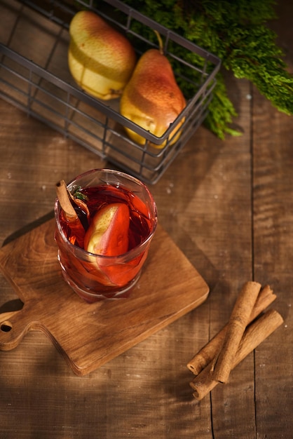 Glass of Cider pear cocktail or lemonade cinnamon sticks anise stars on wooden background