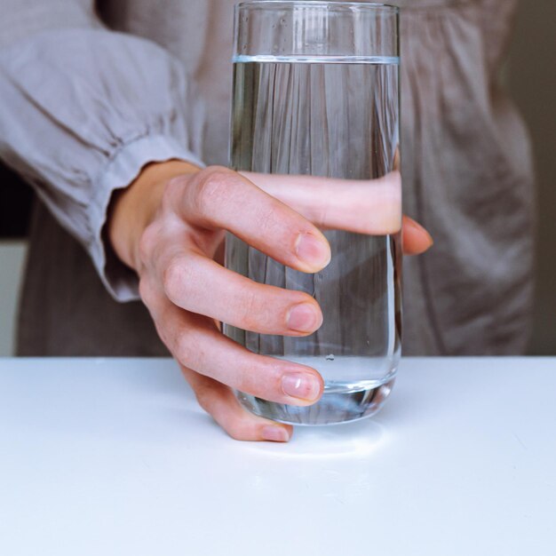 glass of clean water in woman's hand