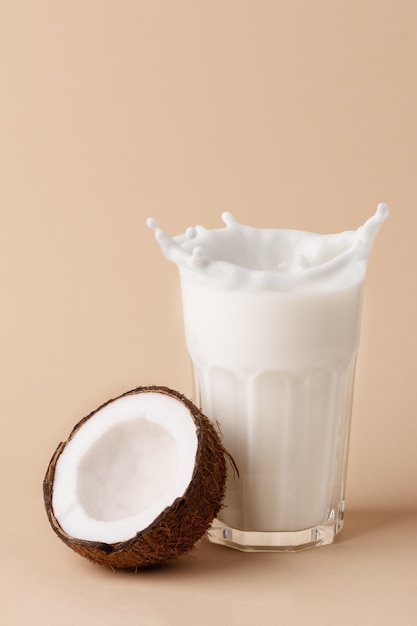 A glass of coconut milk and a half of coconut Creative composition with coconut and milk