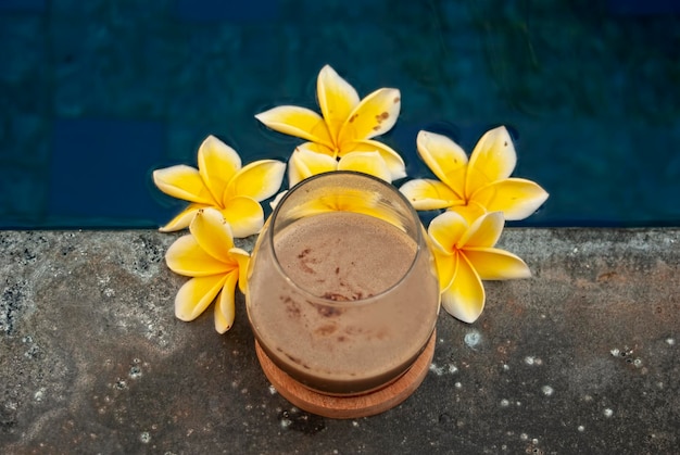 Glass of coffee latte on beautiful swimming pool