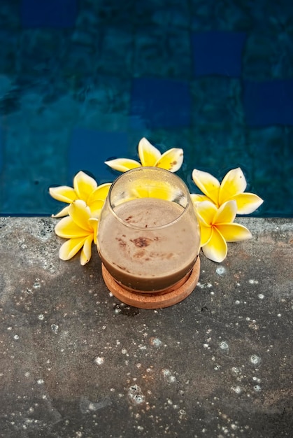 Glass of coffee latte on beautiful swimming pool