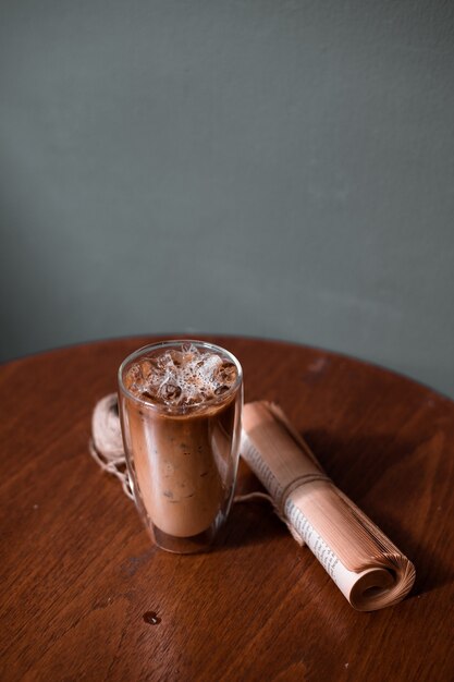 Foto bicchiere di caffè sul tavolo e muro grigio