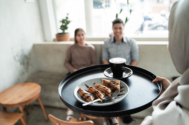 Glass of coffee and toast on a tray is served