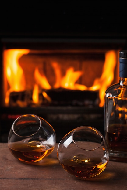 A glass of cognac in front of fireplace
