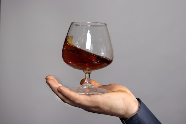 A glass of cognac in the male palm