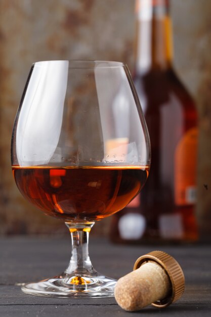 Glass of cognac on rustic ferruginous wall