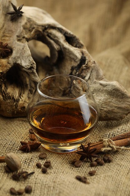 Glass of cognac with spice Cloth background with copy space