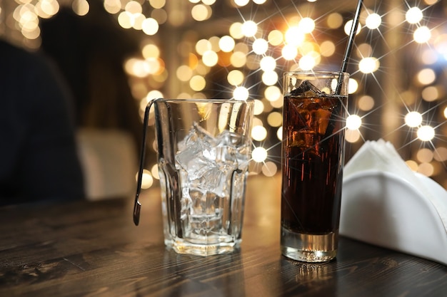 テーブルの上に氷と冷たいアルコール飲料のガラス