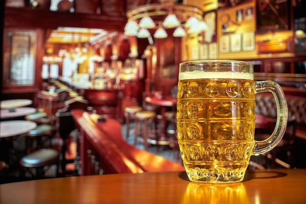 오래된 영국식 아일랜드 펍의 탁자 위에 놓인 시원한 맥주 한 잔. 메뉴 디자인. 맥주 배너입니다. 해피 아워