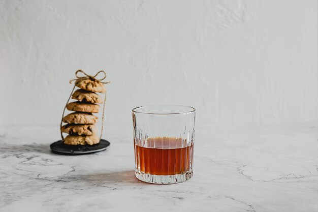 A glass of cold brew coffee, a stack of oatmeal cookies