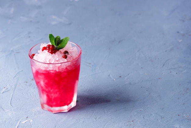 Glass of Cold Cocktail with Cranberry and Vodka Decorated with Mint and Ripe Cranberries