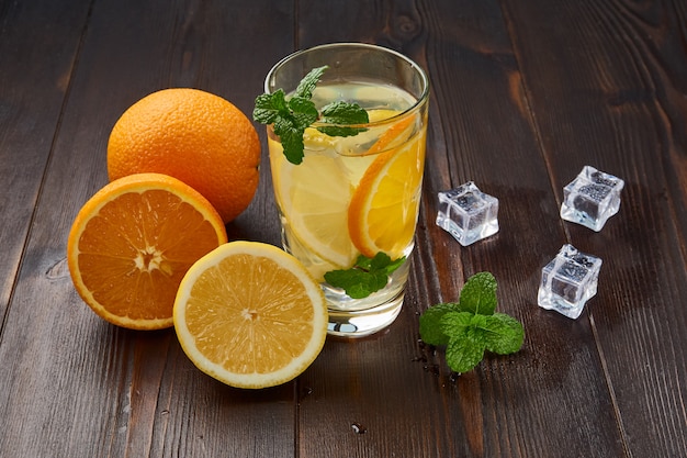 Glass of cold lemonade with orange and lemon