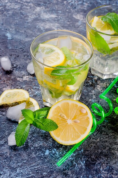 Glass of a cold mojito, juicy slised lemon and mint 