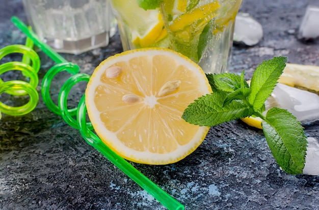 Glass of a cold mojito, juicy slised lemon and mint 