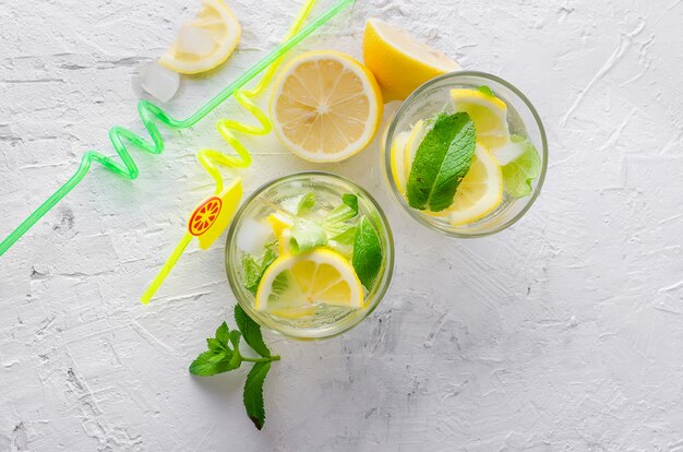 Glass of a cold mojito, juicy slised lemon and mint 