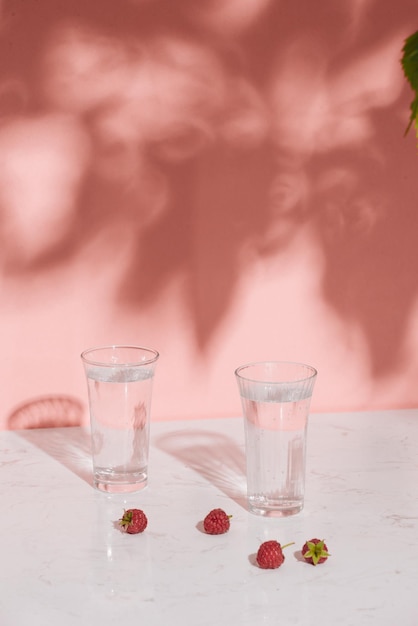 明るい背景に新鮮な果実と冷たいラズベリー サイダーのグラス