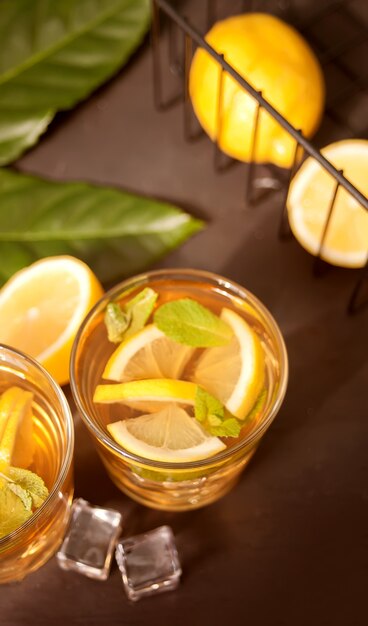 Glass of cold refreshment tea with ice and lemon fruit.