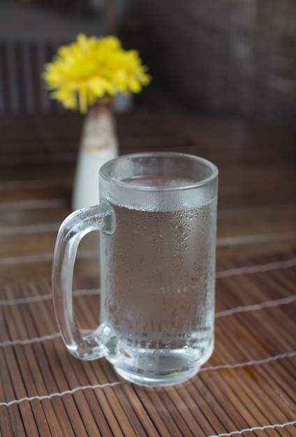 Glass of cold water on wooden table