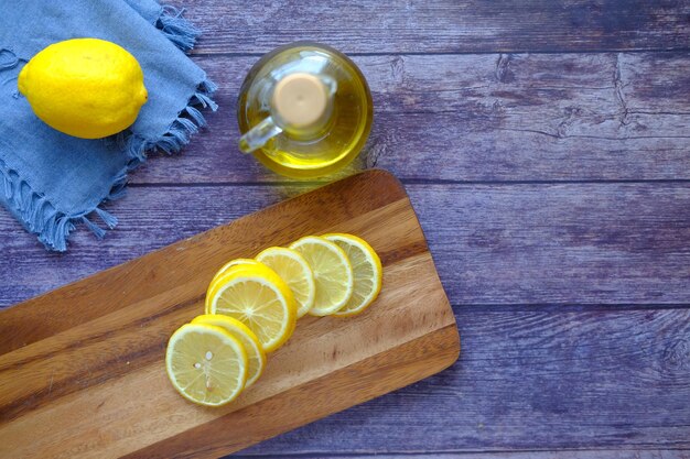 glass container of oil and lemon on table