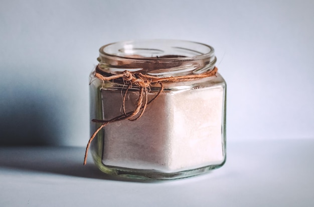 Photo glass container with sugar on white background