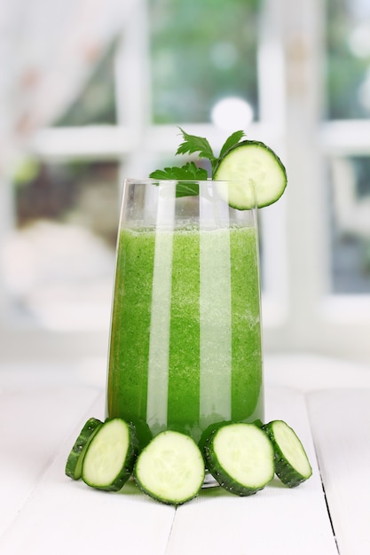 Glass of cucumber juice on wooden table