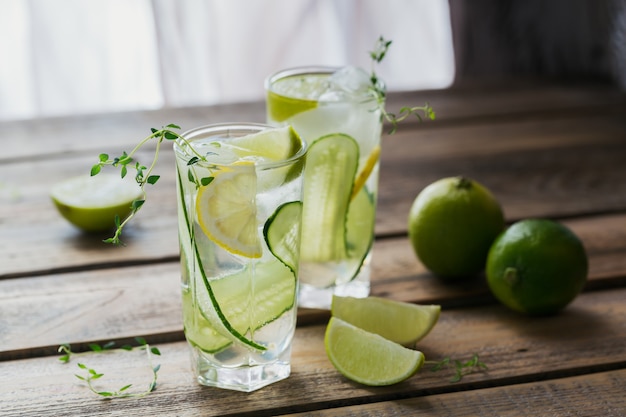 Glass of cucumber soda drink on wooden table. Summer healthy detox infused water, lemonade or cocktail