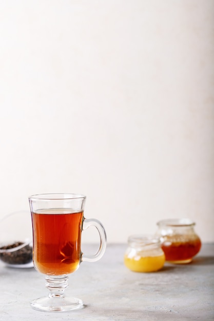 Glass cup of black tea served with honey