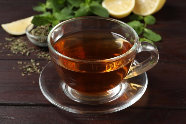 Glass cup of freshly brewed tea on wooden table closeup